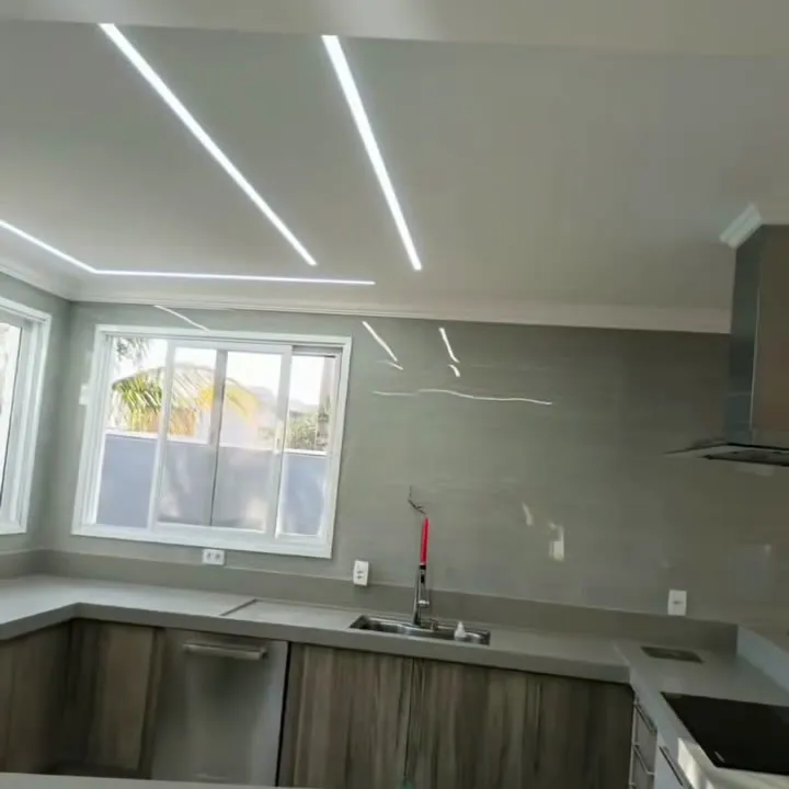 Cozinha com janela, bancada e desenho de LED no teto.